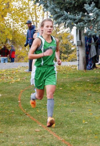 Abby Hurst (12) runs strong as she creates distance between competitiors to hold second place.