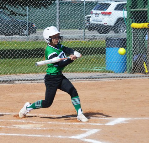 HIGH INSIDE. Ahna Yancey(12) swings at a high ball and sends it sailing