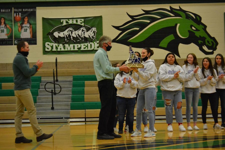 Roger Thomas recieves girls basketball state trophy from Coach 